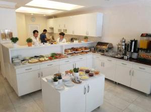 two people in a kitchen with food on counters at B Corner Hotel Bistro in Istanbul