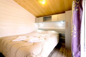 a bed in a room with a wooden ceiling at Chateau De La Plinguetiere in Saint-Aignan-Grand-Lieu