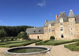 a large stone building with a fountain in front of it at Château du Hardas in Segré