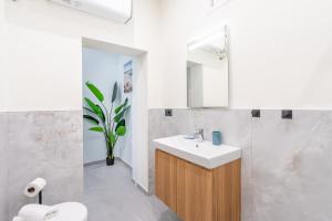 a bathroom with a sink and a toilet and a mirror at Seashell Luxury Rooms Sanremo in Sanremo