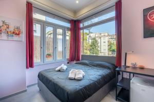 a bedroom with a bed and a desk and windows at Seashell Luxury Rooms Sanremo in Sanremo