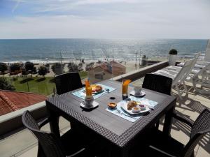 a table with food on top of a balcony with the ocean at CMB Guesthouse in Apúlia