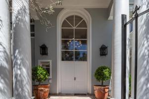a front door of a house with two potted plants at Maison du Cap in Cape Town