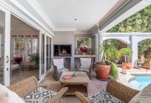 a screened in porch with a pool and a fireplace at Maison du Cap in Cape Town