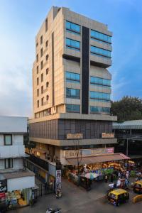 a tall building with a parking lot in front of it at Hotel Olten in Mumbai