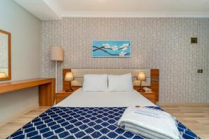 a bedroom with a bed with a blue and white comforter at Uras Beach Hotel in Fethiye +28 photos