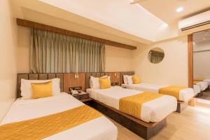 a hotel room with two beds and a window at Hotel Olten in Mumbai +75 photos