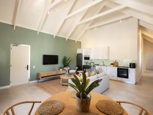 a kitchen and living room with tables and chairs at Cornercade | Unit 1 in Hermanus +26 photos