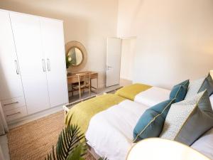 a bedroom with a bed and a table and a mirror at Cornercade | Unit 1 in Hermanus