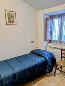 a bedroom with a blue bed and a chair at Lucoli Antico in Vado Lucoli
