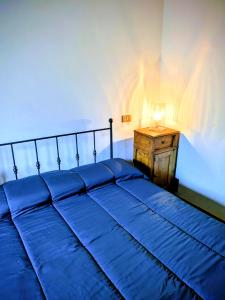 a bedroom with a blue bed and a night stand at Lucoli Antico in Vado Lucoli