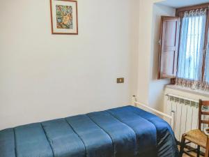 a blue bed in a room with a window at Lucoli Antico in Vado Lucoli +11 photos