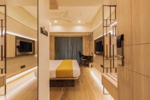 a hotel room with a bed and a desk at Hotel Olten in Mumbai
