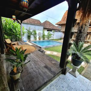 a patio with a table and a swimming pool at Rumah Kayu Sari in Mengwi