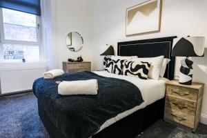 a bedroom with a black and white bed and a mirror at Cambridge Apartment in Glasgow