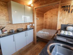 a kitchen with white cabinets and a sink at Rhosgranog Shepherds Hut in Haverfordwest