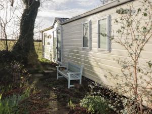 a bench sitting outside of a tiny house at Rhosgranog Caravan in Haverfordwest