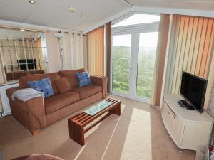 a living room with a couch and a tv at Rhosgranog Caravan in Haverfordwest