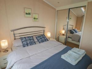 a bedroom with a large bed and a mirror at Rhosgranog Caravan in Haverfordwest