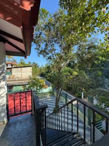 a balcony with a red door and a tree at Kahanda Cinnamon Villa in Angulugaha