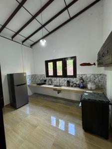a kitchen with a refrigerator and a counter in a room at Kahanda Cinnamon Villa in Angulugaha +18 photos