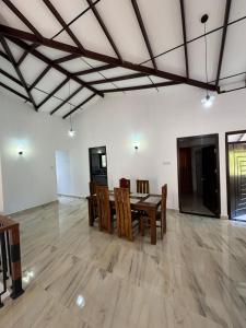 a dining room with a table and chairs in a room at Kahanda Cinnamon Villa in Angulugaha