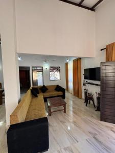 a living room with a couch and a table at Kahanda Cinnamon Villa in Angulugaha