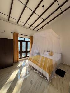 a bedroom with a bed with a mosquito net at Kahanda Cinnamon Villa in Angulugaha