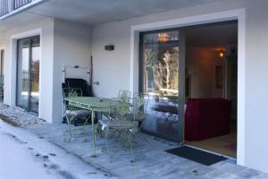 a patio with a table and chairs on a porch at Karwendelperle -419- in Mittenwald +2 photos