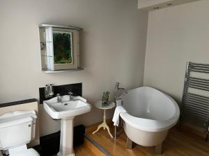 a bathroom with a white tub and a sink at The Silk House in Leek +38 photos