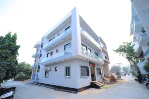 a tall white building with aventh floor at Hotel Yash Palace in Agra