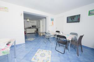 a dining room with tables and chairs and a kitchen at Belvedere in Procida