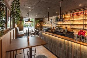 a restaurant with wooden tables and a bar at Smarthotel Schmid - Restaurant & Bar inhouse - Nähe Schlossteich in Sitzenberg