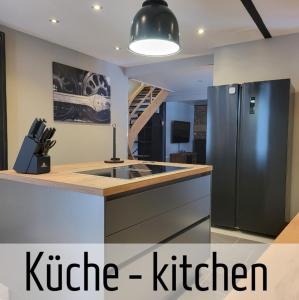 a kitchen with a stainless steel refrigerator and a staircase at Lokschuppen - Backstein-Loft in Bad Oeynhausen