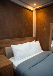 a bedroom with a bed and a wooden wall at Yankers Royal Hôtel Kinshasa in Kinshasa +6 photos