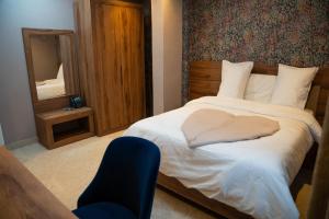 a bedroom with a bed with a mirror and a chair at Yankers Royal Hôtel Kinshasa in Kinshasa