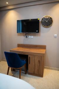 a room with a desk and a clock on a wall at Yankers Royal Hôtel Kinshasa in Kinshasa