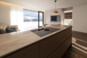 a kitchen with a large island with a large window at Trutscher Häusl in Villnöss - Chalet in den Dolomiten mit Blick auf die Geisler in Funes