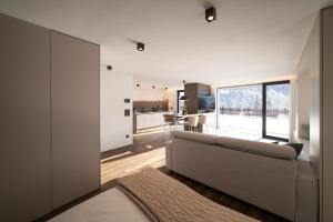 a living room with a couch and a kitchen at Trutscher Häusl in Villnöss - Chalet in den Dolomiten mit Blick auf die Geisler in Funes
