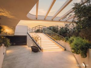 a set of stairs in a building with plants at Mercury Suites Apartment with Pool Access in St Julians in St. Julianʼs