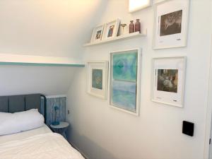 a bedroom with a bed and pictures on the wall at De Korre 10 in Callantsoog