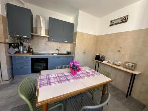 a kitchen with a table with a vase of flowers on it at Ziva's house apartment in Abbiategrasso in Abbiategrasso