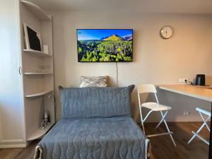 a bedroom with a blue bed and a desk and a table at Гнёздышко in Visaginas