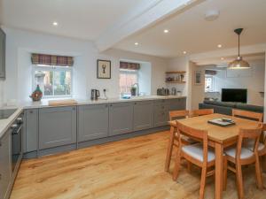 a kitchen and dining room with a wooden table at The Old Workshop in Dulverton