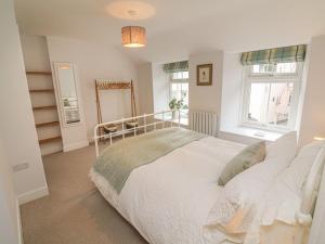 a bedroom with a white bed and a window at The Old Workshop in Dulverton