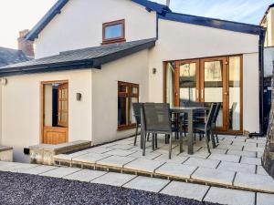 a patio with a table and chairs in front of a house at The Old Workshop in Dulverton
