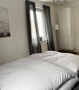 a white bed in a bedroom with a window at City Flair by Zirwick Apartment in Weiden