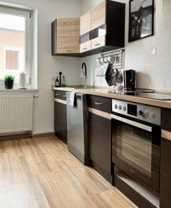 a kitchen with stainless steel appliances and wooden floors at City Flair by Zirwick Apartment in Weiden