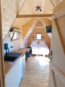 a tiny house with a kitchen and a bedroom at Tiny Chaumière - Escapade Romantique - Chaumière et Jacuzzi Privatif proche Pont-Aven in Riec-sur-Bélon