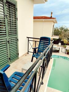 two blue chairs sitting on a balcony next to a swimming pool at Sunset View in Polis Chrysochous